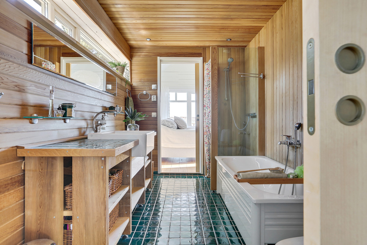 Photo of a mid-sized beach style bathroom in Gothenburg with brown cabinets, a corner shower, white tile, brown walls, a wall-mount sink, brown floor and open cabinets.