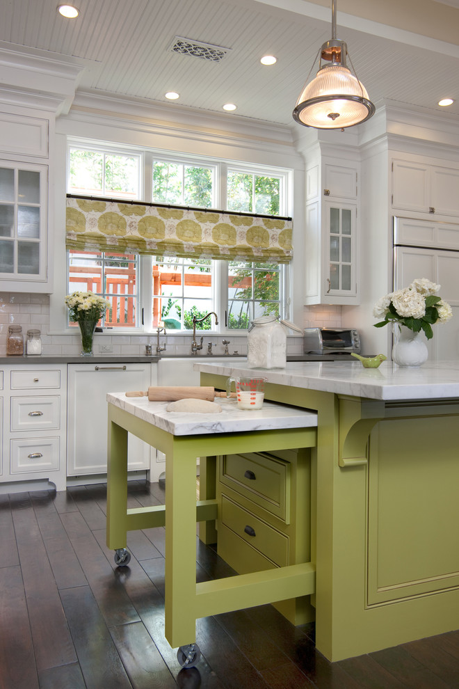 West Coast Hamptons - The kitchen, breakfast room and family room are all open to one another. The kitchen has a large twelve foot island topped with Calacatta marble and features a roll-out kneading table, and room to seat the whole family. The sunlight breakfast room opens onto the patio which has a built-in barbeque, and both bar top seating and a built in bench for outdoor dining. The large family room features a cozy fireplace, TV media, and a large built-in bookcase. The adjoining craft room is separated by a set of pocket french doors; where the kids can be visible from the family room as they do their homework.