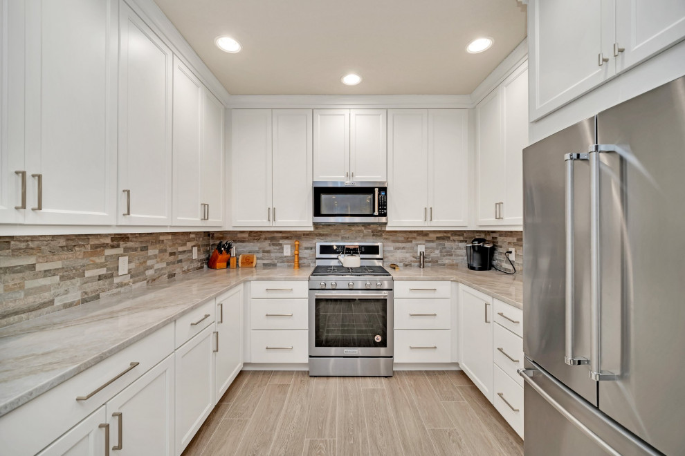 Mid-sized transitional galley enclosed kitchen photo in Orlando with shaker cabinets, white cabinets and stainless steel appliances
