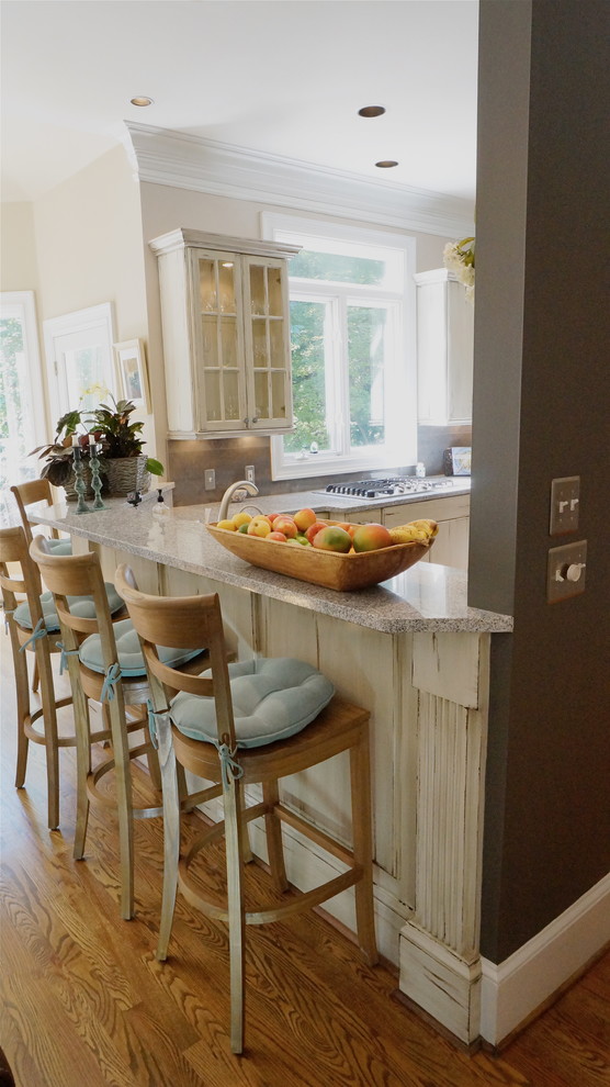 Example of a large mountain style u-shaped medium tone wood floor eat-in kitchen design in Atlanta with an undermount sink, flat-panel cabinets, distressed cabinets, quartz countertops, white backsplash, ceramic backsplash, stainless steel appliances and beige walls