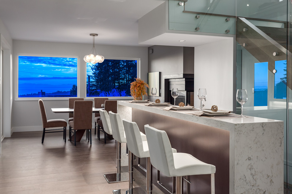 Large contemporary seated home bar in Vancouver with quartzite benchtops, white splashback, stone slab splashback, porcelain floors and white benchtop.