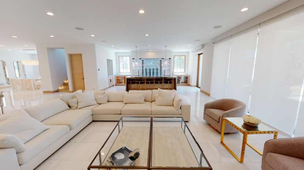 Photo of an expansive contemporary open concept family room in Orange County with white walls, porcelain floors and white floor.