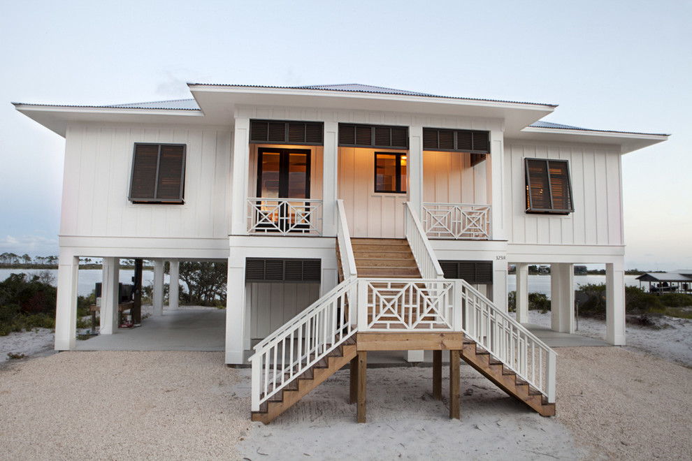 Inspiration for a mid-sized beach style one-storey white house exterior in Miami with wood siding, a hip roof and a metal roof.