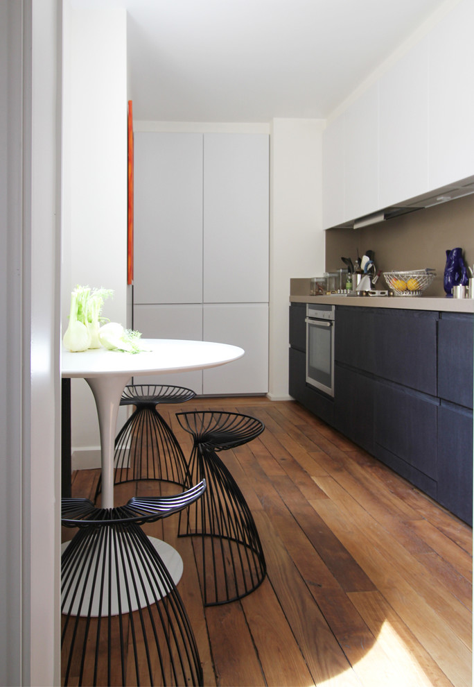 Inspiration for a mid-sized contemporary single-wall eat-in kitchen in Paris with flat-panel cabinets, white cabinets and no island.