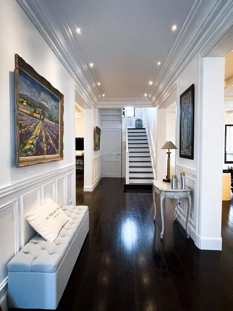Immagine di un grande ingresso chic con pareti bianche, parquet scuro, pavimento marrone e soffitto a cassettoni