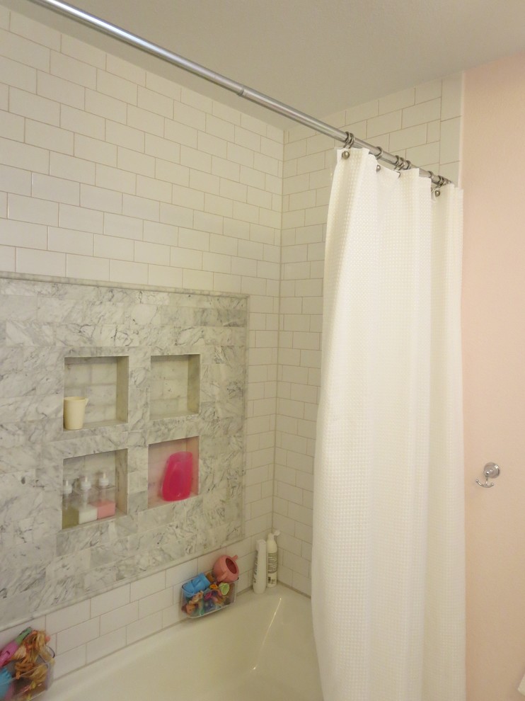This is an example of a mid-sized transitional kids bathroom in Austin with shaker cabinets, white cabinets, an alcove tub, a shower/bathtub combo, pink walls, porcelain floors, an undermount sink, a two-piece toilet, multi-coloured tile, marble and quartzite benchtops.