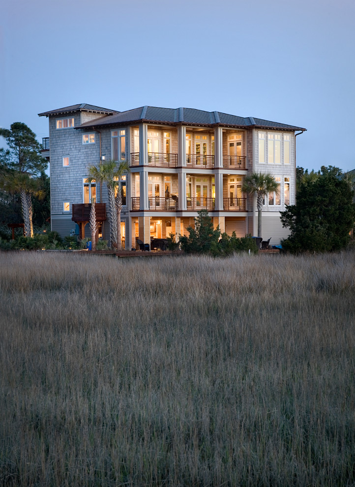 Design ideas for a beach style three-storey grey exterior in Charleston with wood siding and a hip roof.