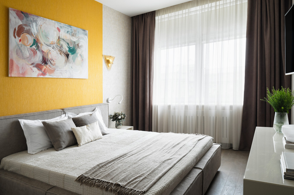 На фото: хозяйская спальня среднего размера с желтыми стенами и паркетным полом среднего тона без камина с