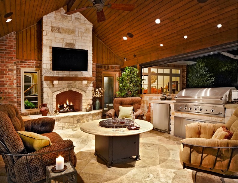 Large traditional backyard patio in Dallas with an outdoor kitchen, a roof extension and natural stone pavers.