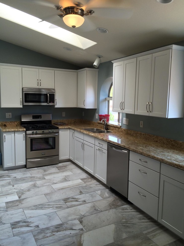 Kitchen - large transitional l-shaped porcelain tile and gray floor kitchen idea in Phoenix with a double-bowl sink, shaker cabinets, white cabinets, granite countertops, stainless steel appliances and no island