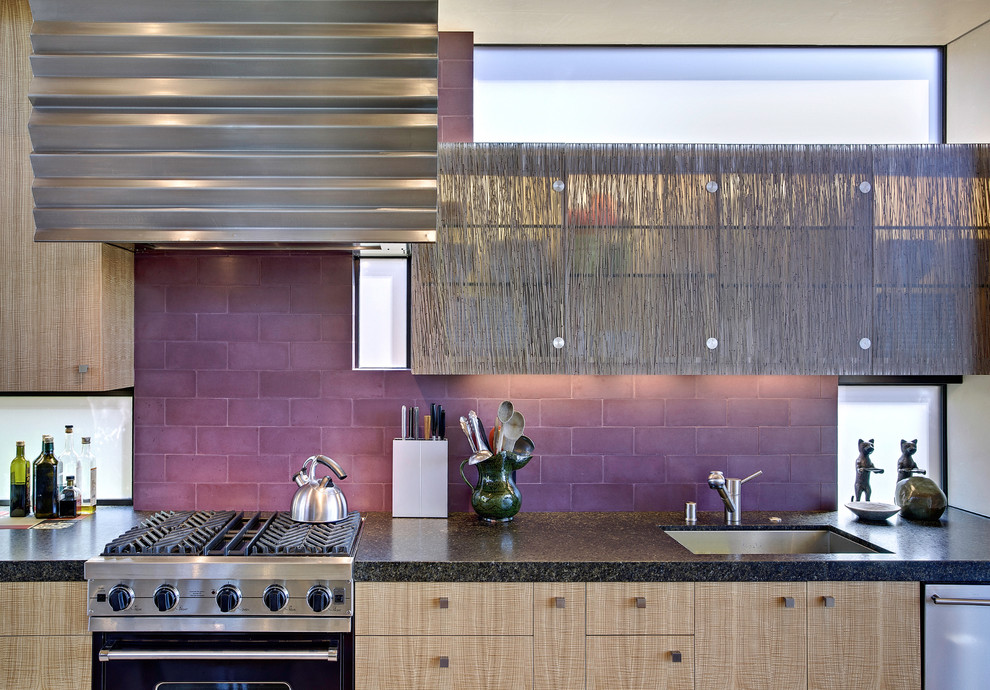 This is an example of a beach style galley eat-in kitchen in San Francisco with subway tile splashback, flat-panel cabinets, light wood cabinets, granite benchtops, an undermount sink, black appliances and with island.