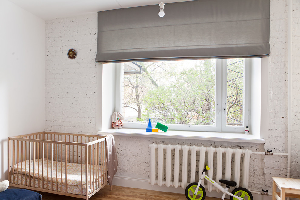 Imagen de habitación de bebé niña industrial de tamaño medio con paredes blancas, suelo de madera pintada y suelo beige