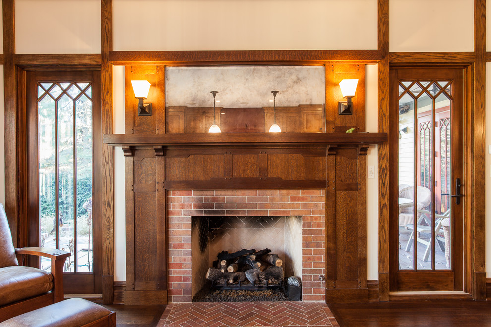 This is an example of a mid-sized arts and crafts enclosed family room in Chicago with beige walls, dark hardwood floors, a standard fireplace, a brick fireplace surround, no tv and brown floor.