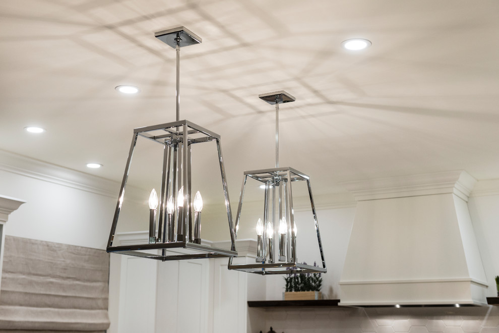 Example of a mid-sized transitional u-shaped medium tone wood floor and brown floor home design design in Vancouver with an undermount sink, recessed-panel cabinets, white cabinets, quartz countertops, white backsplash, porcelain backsplash, stainless steel appliances and an island
