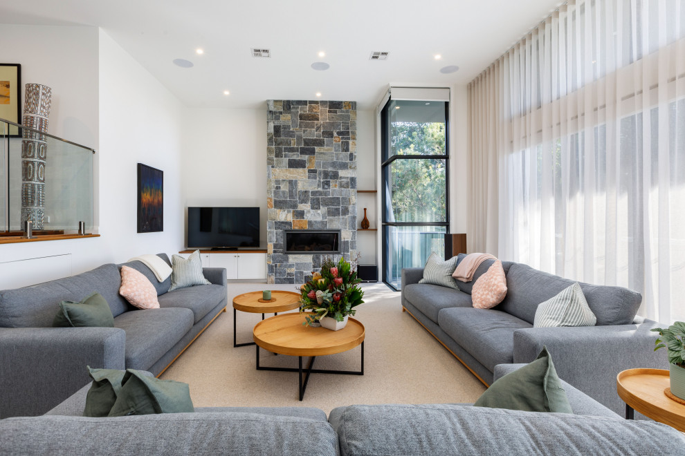 Contemporary formal open concept living room in Canberra - Queanbeyan with carpet, a standard fireplace, a stone fireplace surround, white walls, a freestanding tv and beige floor.