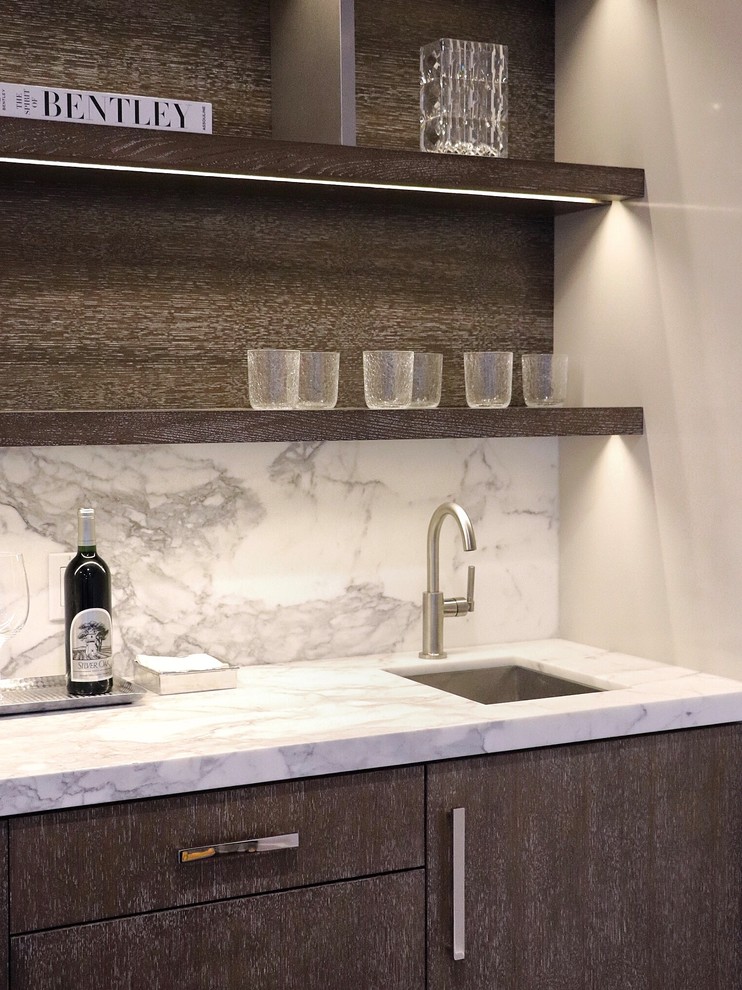 Inspiration for a mid-sized transitional single-wall wet bar in New York with an undermount sink, flat-panel cabinets, medium wood cabinets, marble benchtops, white splashback, marble splashback, dark hardwood floors, brown floor and white benchtop.
