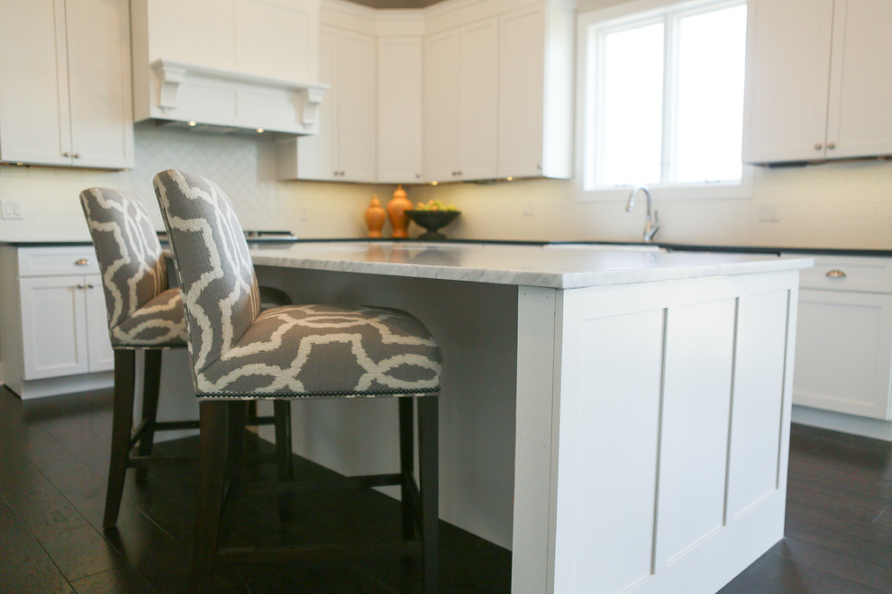 Eat-in kitchen - large transitional u-shaped dark wood floor eat-in kitchen idea in Chicago with a farmhouse sink, shaker cabinets, yellow cabinets, granite countertops, white backsplash, subway tile backsplash, stainless steel appliances and an island