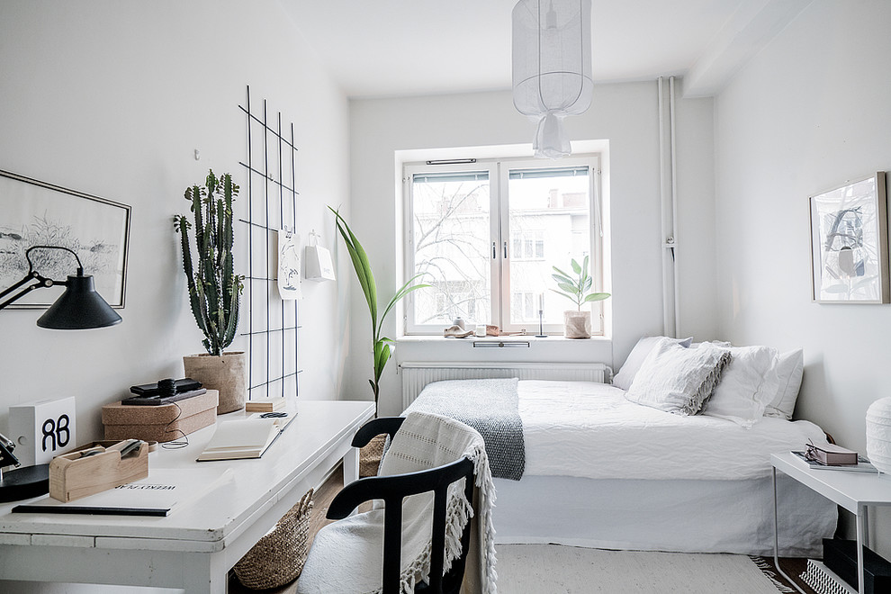 Scandinavian bedroom in Stockholm with white walls, dark hardwood floors and brown floor.