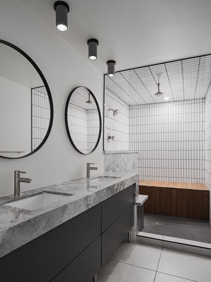 Bild på ett mellanstort funkis grå grått en-suite badrum, med grå skåp, ett badkar i en alkov, en dusch i en alkov, en toalettstol med hel cisternkåpa, vit kakel, porslinskakel, grå väggar, klinkergolv i porslin, ett undermonterad handfat, granitbänkskiva, grått golv och med dusch som är öppen