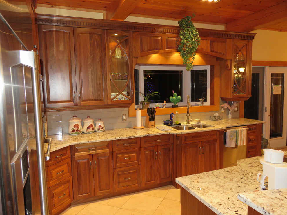 Large transitional l-shaped ceramic tile and beige floor open concept kitchen photo with raised-panel cabinets, medium tone wood cabinets, granite countertops, stainless steel appliances, an island, a double-bowl sink, white backsplash and subway tile backsplash