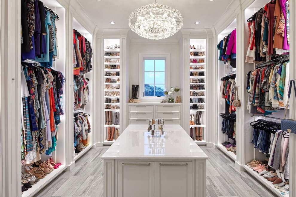 This is an example of a traditional walk-in wardrobe in Houston with beaded inset cabinets, white cabinets and grey floor.