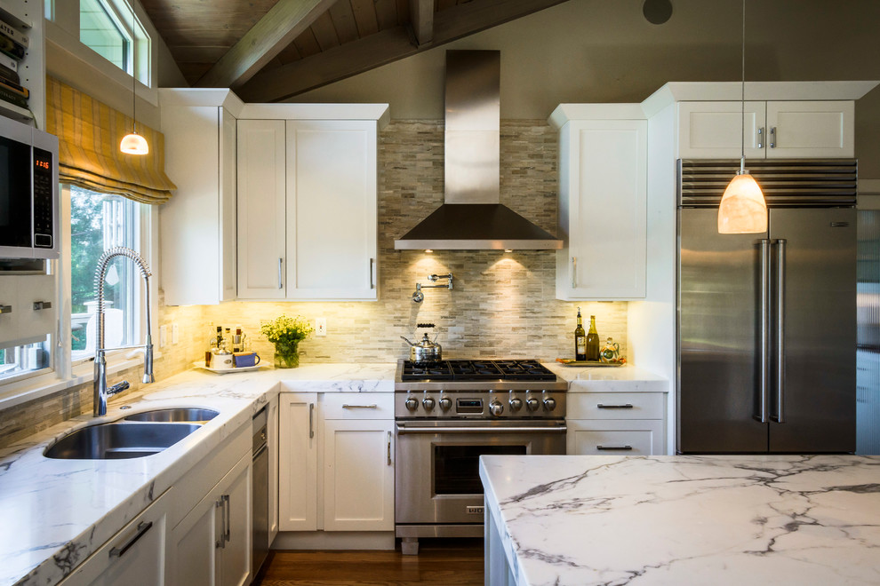 Inspiration for a large country l-shaped eat-in kitchen in San Francisco with white cabinets, marble benchtops, beige splashback, stainless steel appliances, dark hardwood floors, with island, a double-bowl sink, shaker cabinets and stone tile splashback.