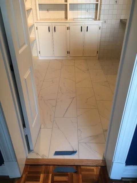 Photo of a mid-sized traditional 3/4 bathroom in DC Metro with raised-panel cabinets, white cabinets, beige tile, ceramic tile and porcelain floors.