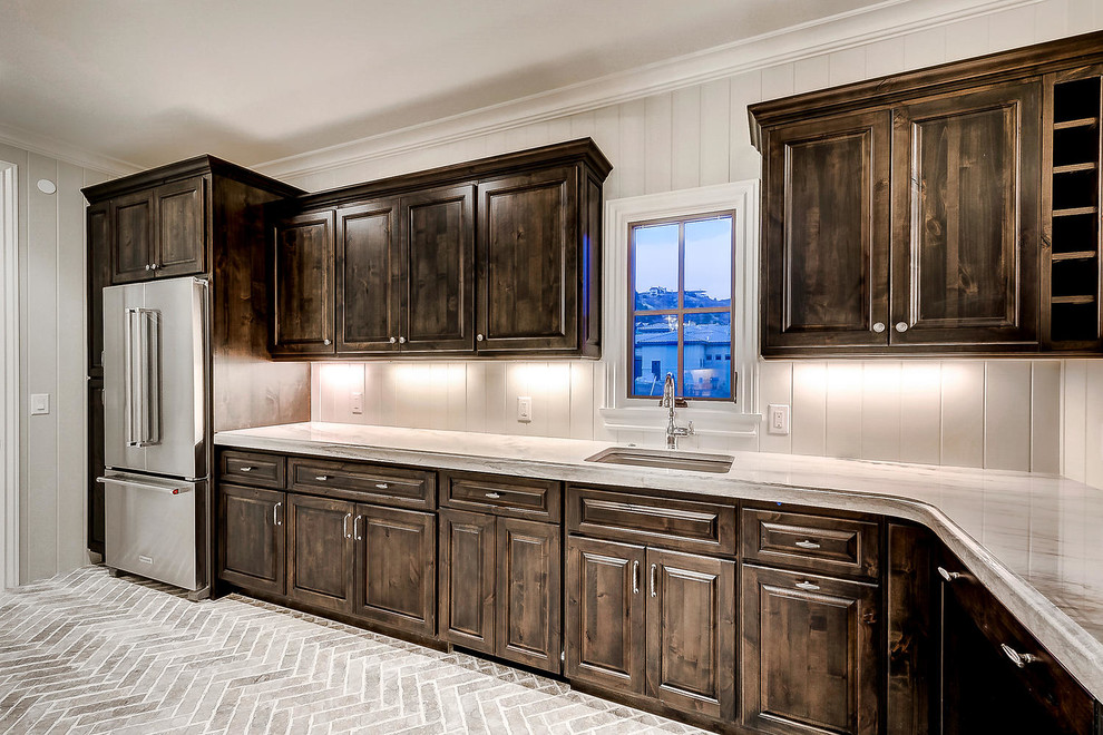 Inspiration for a large l-shaped kitchen pantry in Denver with an undermount sink, raised-panel cabinets, dark wood cabinets, marble benchtops, white splashback, timber splashback, stainless steel appliances, brick floors, no island, grey floor and beige benchtop.