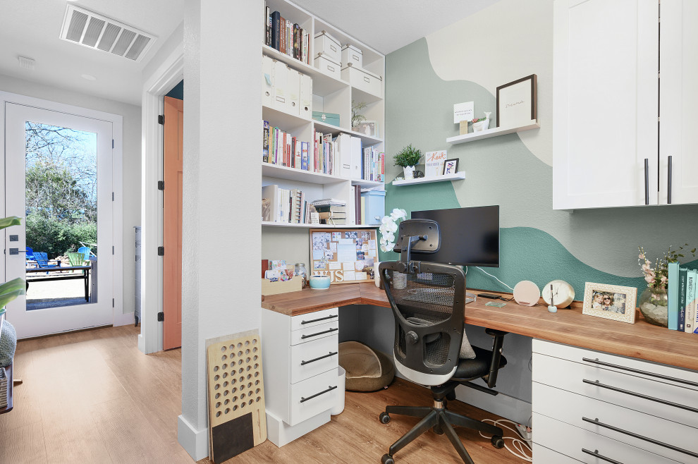 Immagine di un ufficio country di medie dimensioni con pareti bianche, pavimento in legno massello medio, scrivania incassata e pavimento marrone