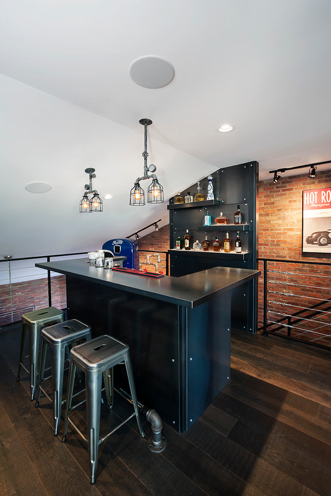 Inspiration for an industrial seated home bar in Calgary with black cabinets and dark hardwood floors.