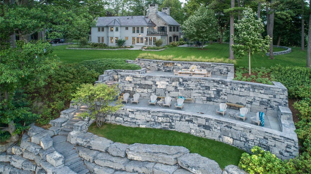 Inspiration for a large traditional sloped partial sun garden in Burlington with natural stone pavers.