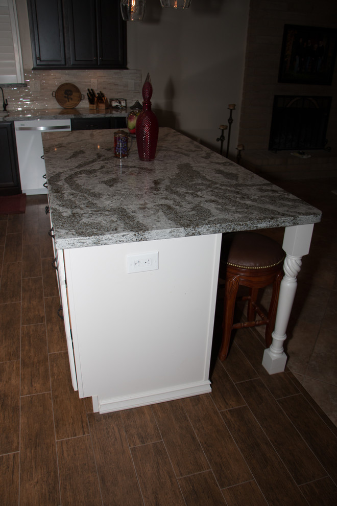 Open concept kitchen - mid-sized transitional l-shaped porcelain tile open concept kitchen idea with an undermount sink, flat-panel cabinets, dark wood cabinets, quartz countertops, beige backsplash, glass sheet backsplash, white appliances and an island