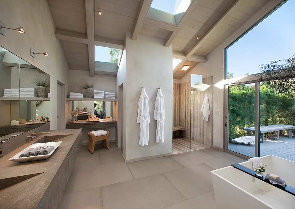 Expansive contemporary master bathroom in Santa Barbara with flat-panel cabinets, grey cabinets, a freestanding tub, an open shower, grey walls, an integrated sink, porcelain floors, engineered quartz benchtops and an open shower.