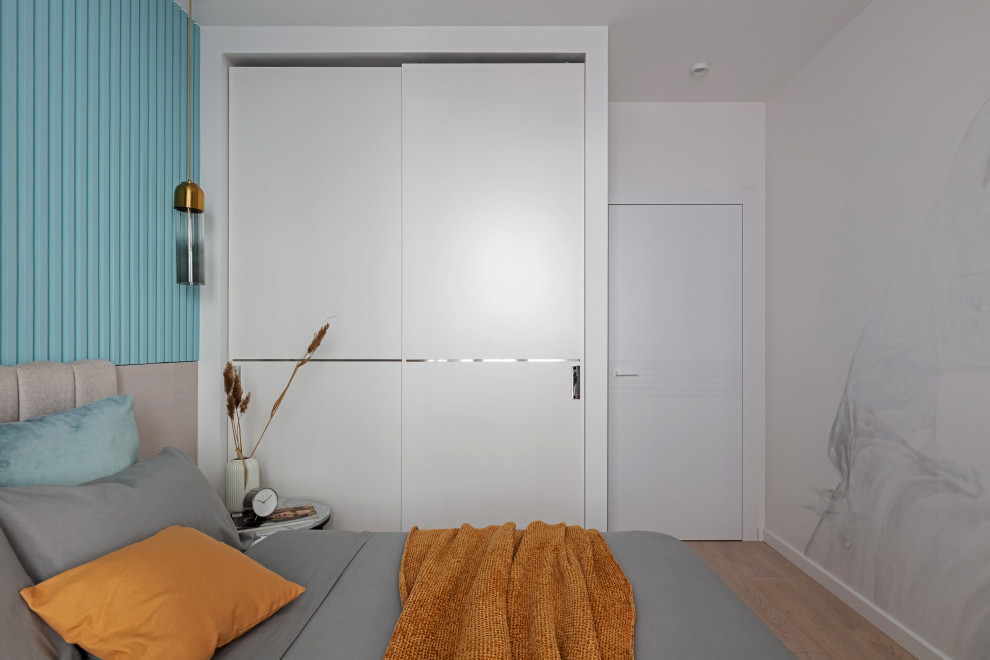 Idée de décoration pour une petite chambre parentale design avec un mur bleu, un sol en bois brun, un sol beige et du lambris.