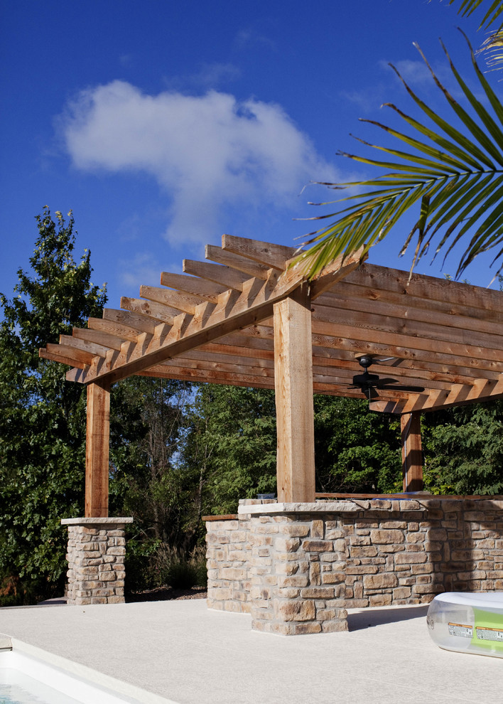 Design ideas for a mid-sized country backyard patio in Louisville with a fire feature, concrete slab and a pergola.
