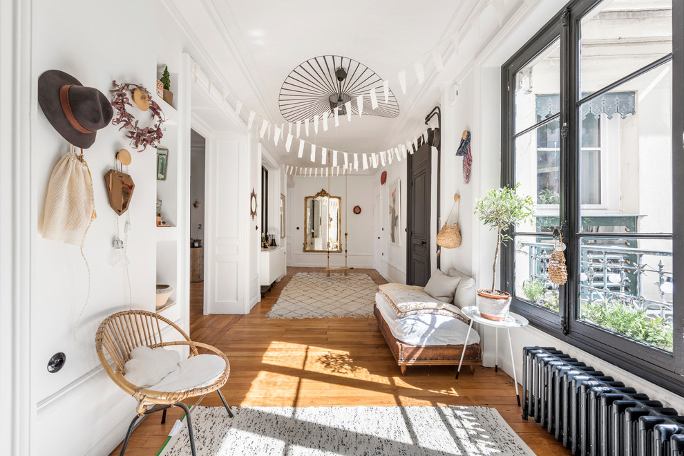 Eclectic entry hall in Lyon with white walls, medium hardwood floors, a single front door and a black front door.