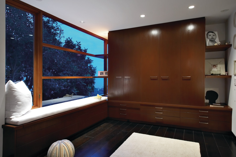 Design ideas for a contemporary storage and wardrobe in Orange County with dark wood cabinets.