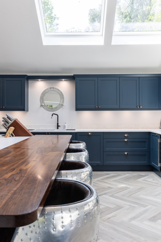 Foto di una grande cucina design con ante in stile shaker, ante blu, top in quarzite e top bianco