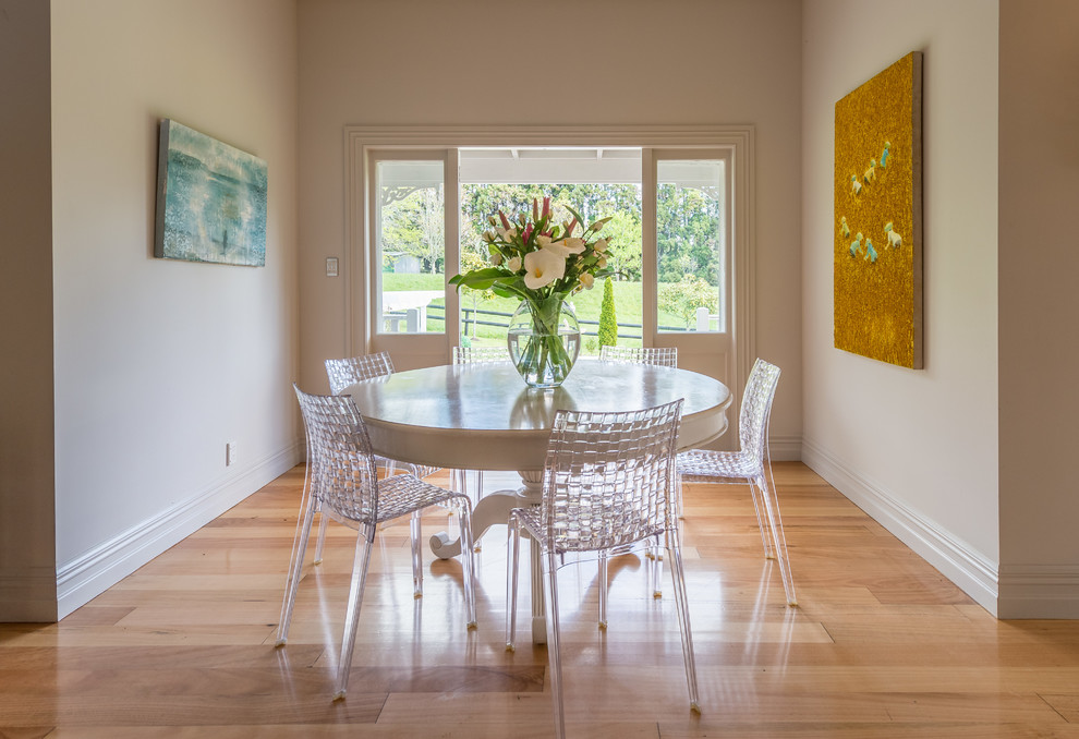 Photo of a transitional separate dining room in Auckland with grey walls, medium hardwood floors and brown floor.