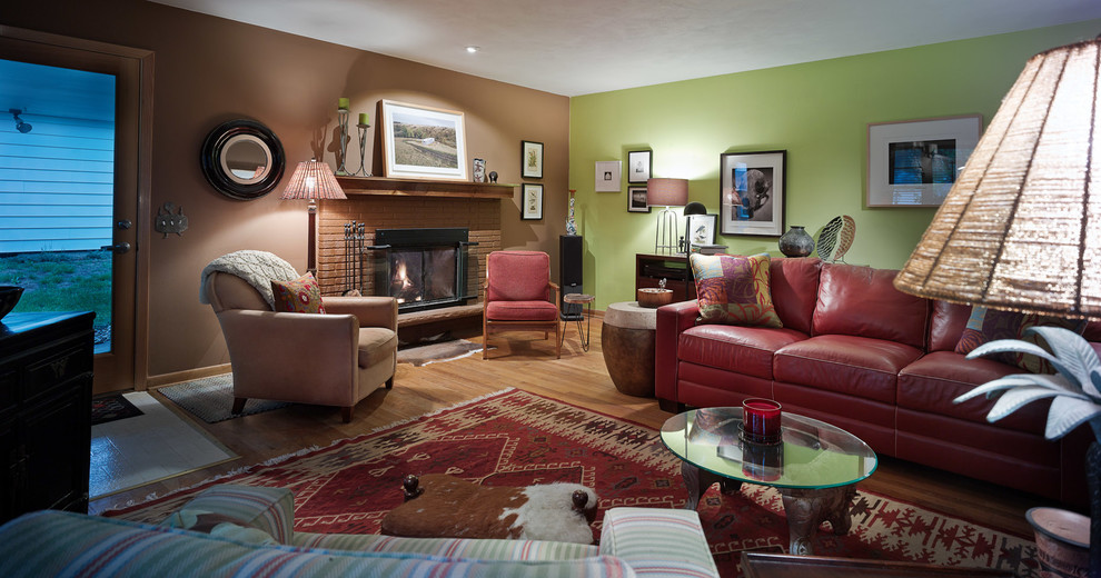 This is an example of a large eclectic enclosed living room in Other with green walls, light hardwood floors, a standard fireplace, a brick fireplace surround and no tv.