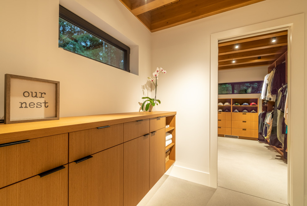 На фото: гардеробная комната среднего размера в современном стиле с плоскими фасадами, фасадами цвета дерева среднего тона, серым полом и балками на потолке