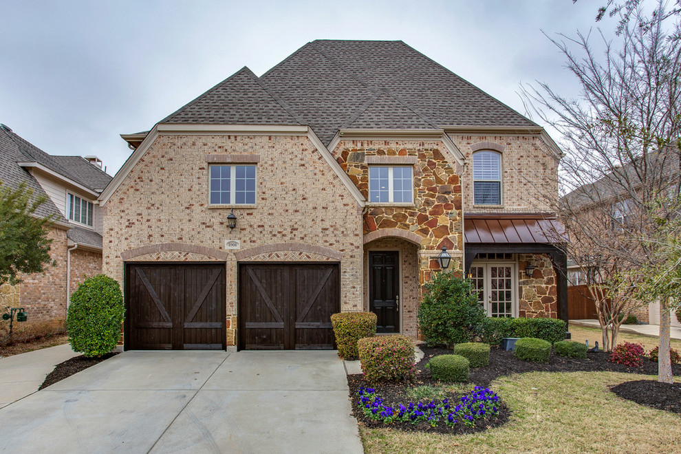 Large traditional two-storey brick beige exterior in Dallas.