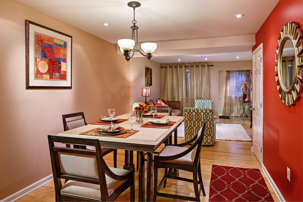 На фото: гостиная комната среднего размера в стиле неоклассика (современная классика) с красными стенами и светлым паркетным полом без камина с