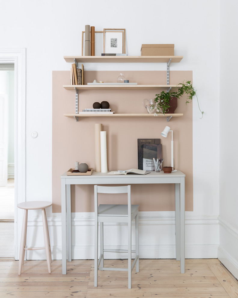 Inspiration for a small scandinavian home office in Stockholm with light hardwood floors, a freestanding desk, beige floor and beige walls.