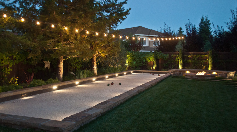 Photo of a large traditional backyard outdoor sport court in San Francisco with a fire feature and natural stone pavers.