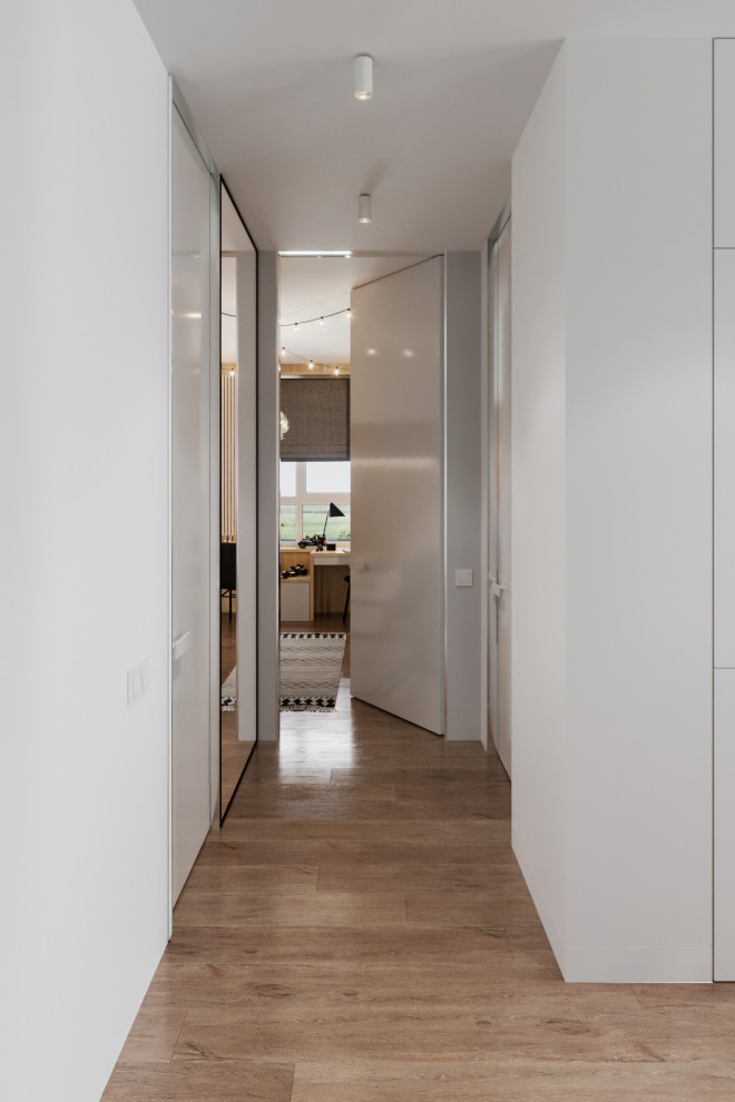 Small contemporary front door in Other with white walls, vinyl floors, a light wood front door and beige floor.