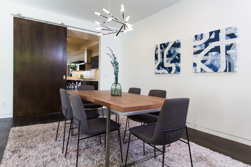 Photo of a contemporary separate dining room in Los Angeles with white walls and dark hardwood floors.