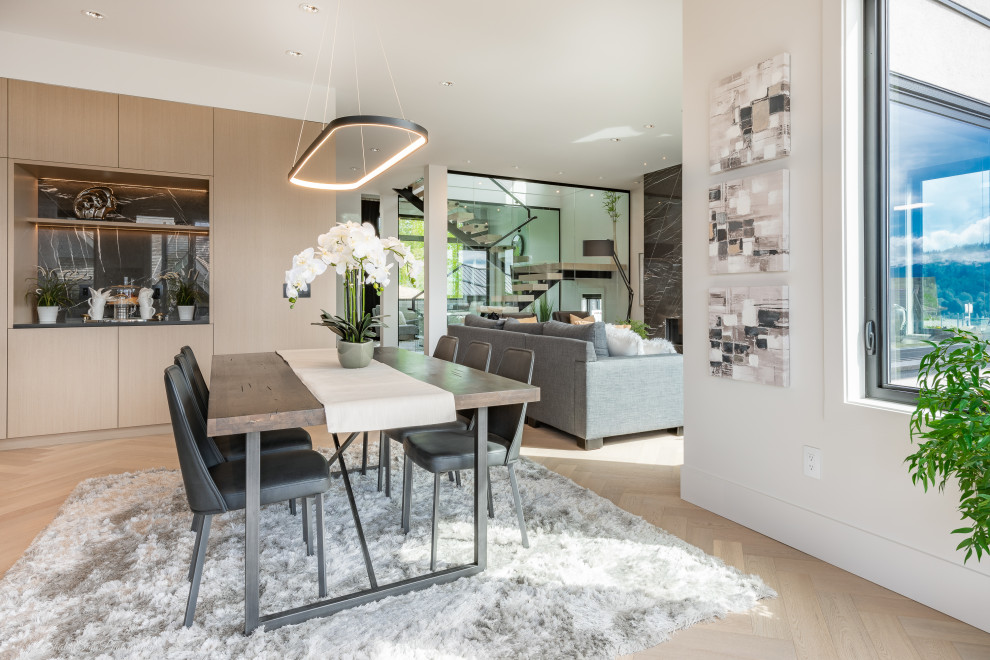Inspiration for a mid-sized contemporary light wood floor kitchen/dining room combo remodel in Vancouver with white walls, a standard fireplace and a stone fireplace