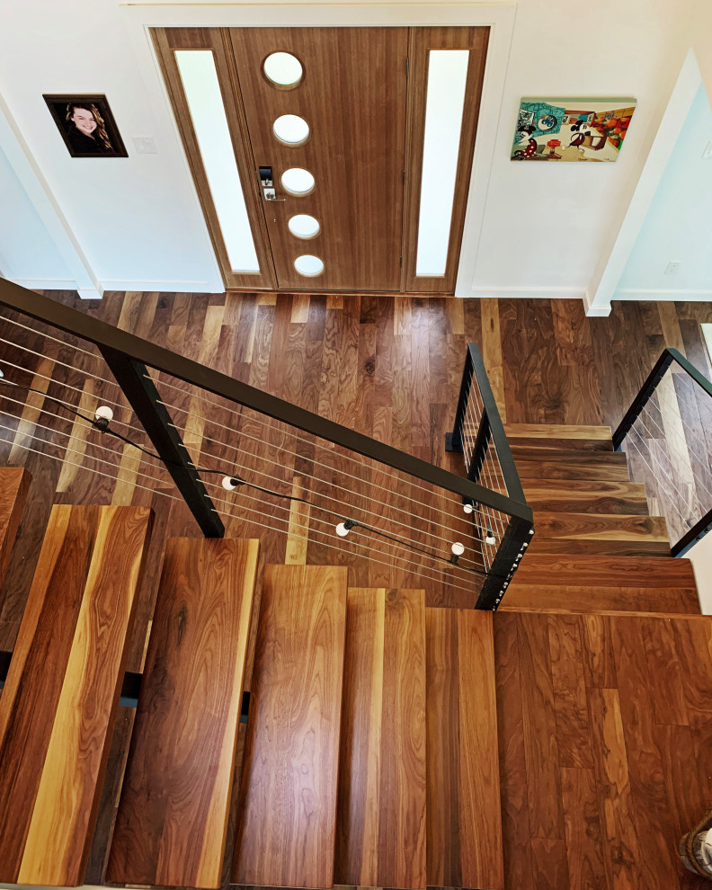 This is an example of a mid-sized modern wood floating staircase in Other with open risers and metal railing.