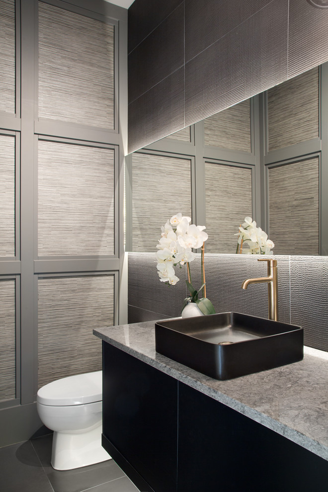 This is an example of a small contemporary powder room in Vancouver with flat-panel cabinets, black cabinets, black tile, ceramic tile, grey walls, a vessel sink, engineered quartz benchtops, black floor and grey benchtops.